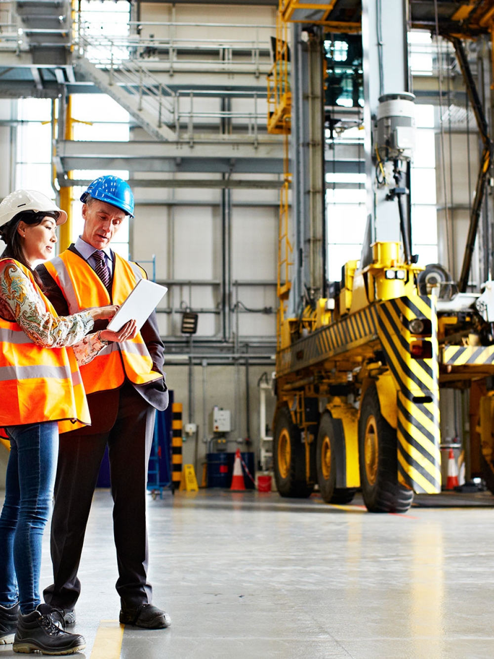 Deux employés dans une usine regardant une tablette