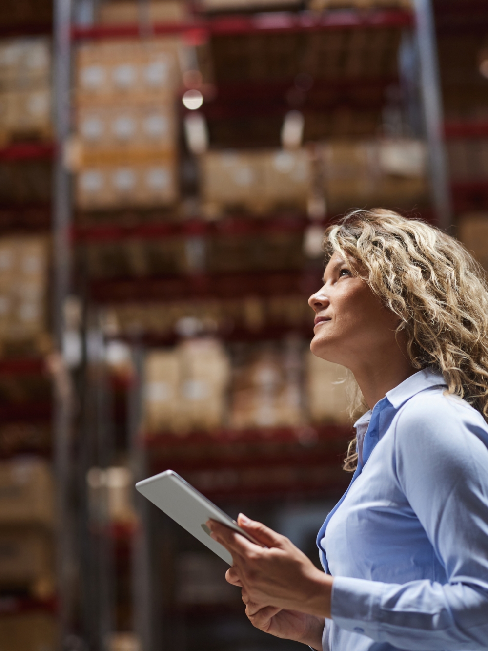 Femme tenant une tablette électronique dans un entrepôt