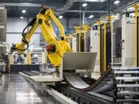 Bras robotisé jaune opérant dans une ligne de production automatisée, manipulant des pièces métalliques dans un environnement industriel. 