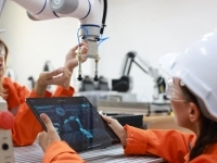 employée vérifiant un robot, tenant une tablette